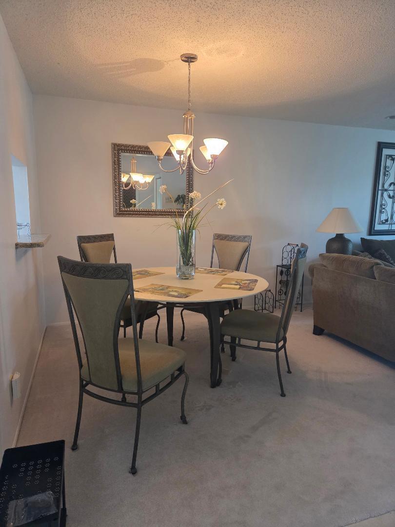 2950 Southeast Ocean Boulevard, Unit 1317 Stuart, FL 34996 - Photo 6 of 19 a view of a dining room with furniture and wooden floor