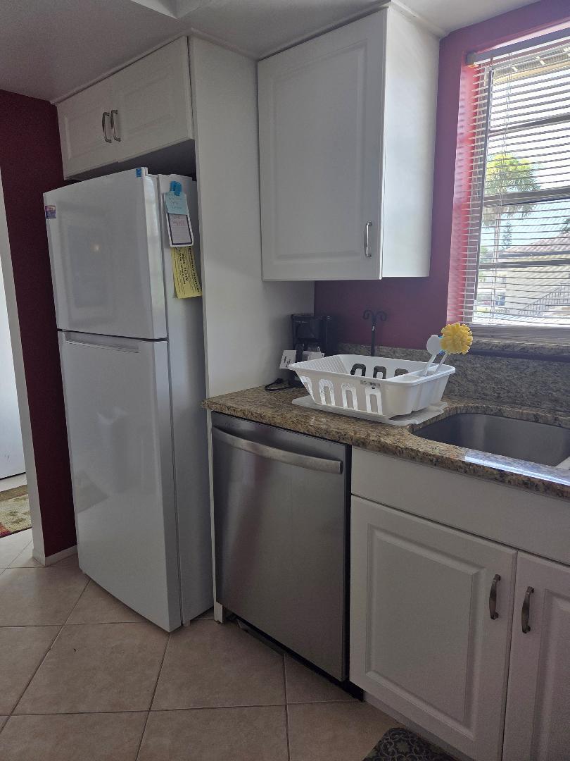 2950 Southeast Ocean Boulevard, Unit 1317 Stuart, FL 34996 - Photo 8 of 19 a white refrigerator freezer sitting inside of a kitchen