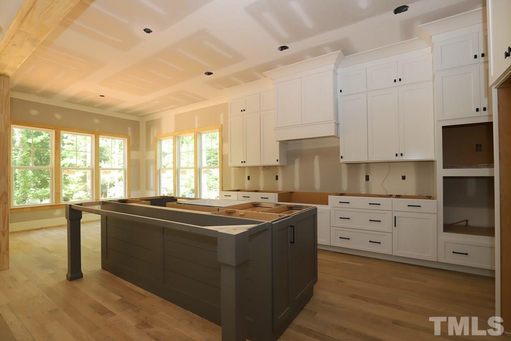 2997 Club Drive Raleigh, NC 27613 - Photo 8 of 30 a kitchen that has a lot of cabinets in it and wooden floors