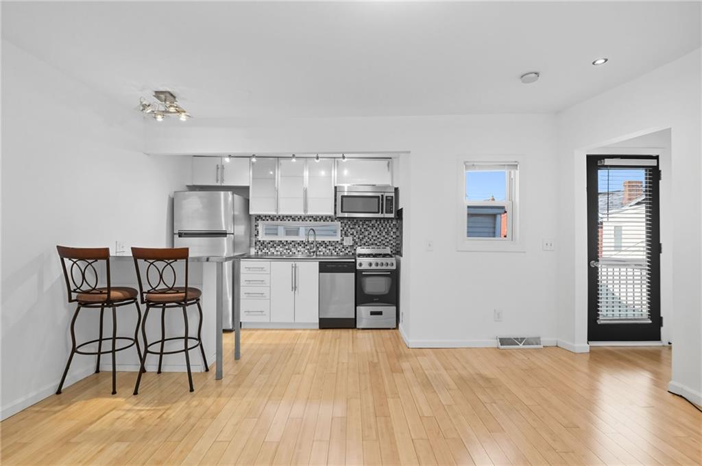 1824 Fox Way Pittsburgh, PA 15203 - Photo 35 of 49 a kitchen with stainless steel appliances kitchen island hardwood floor stove sink and cabinets