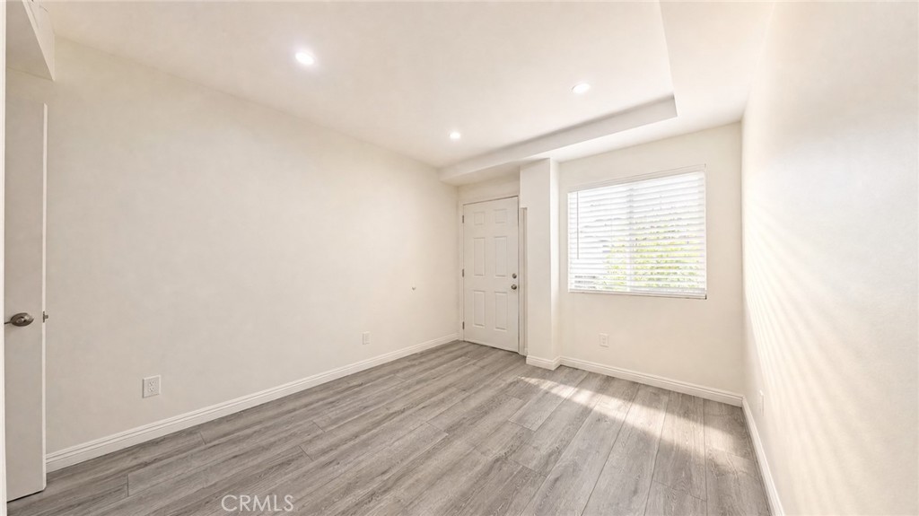 6851 Foothill Boulevard Tujunga, CA 91042 - Photo 39 of 50 an empty room with wooden floor and windows