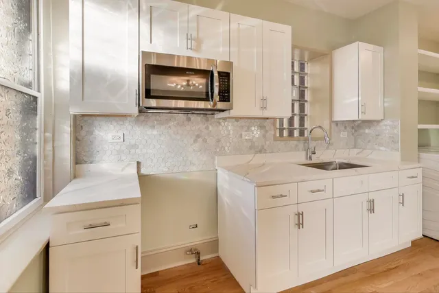 a kitchen with stainless steel appliances white cabinets and a sink