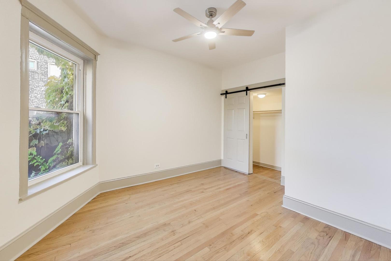 6146 South Evans Avenue, Unit 2 Chicago, IL 60637 - Photo 13 of 20 a view of an empty room with a window and wooden floor