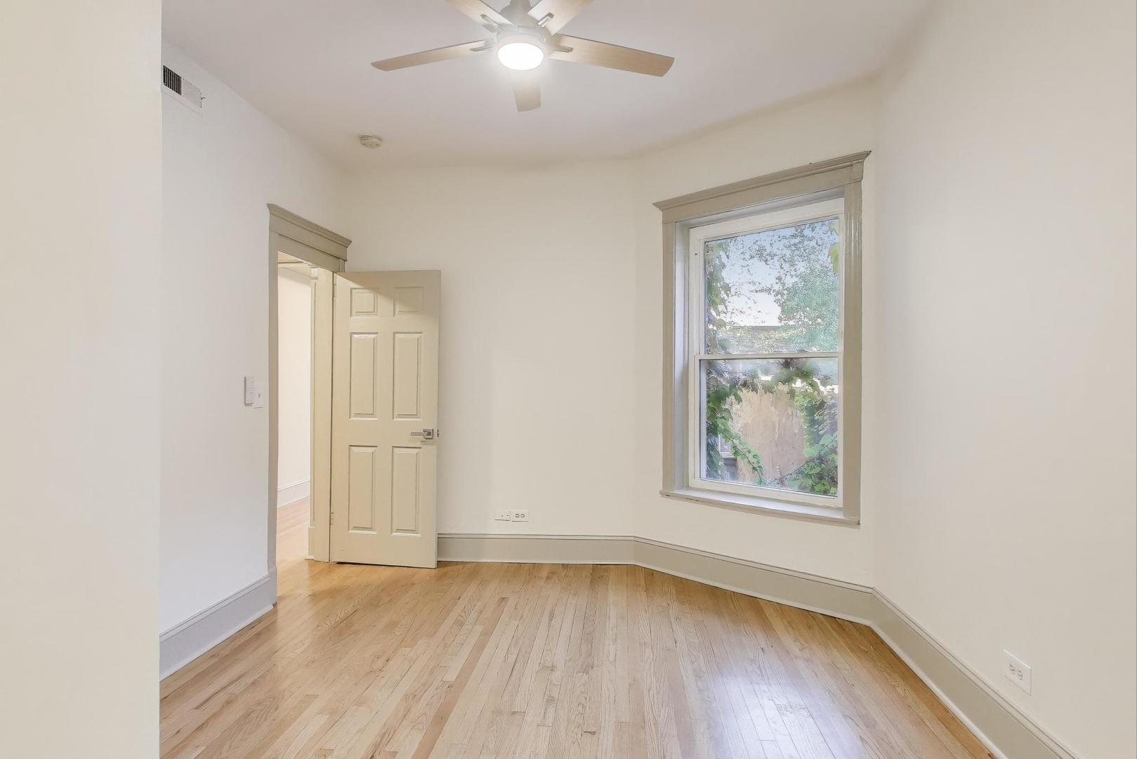 6146 South Evans Avenue, Unit 2 Chicago, IL 60637 - Photo 14 of 20 an empty room with wooden floor and windows