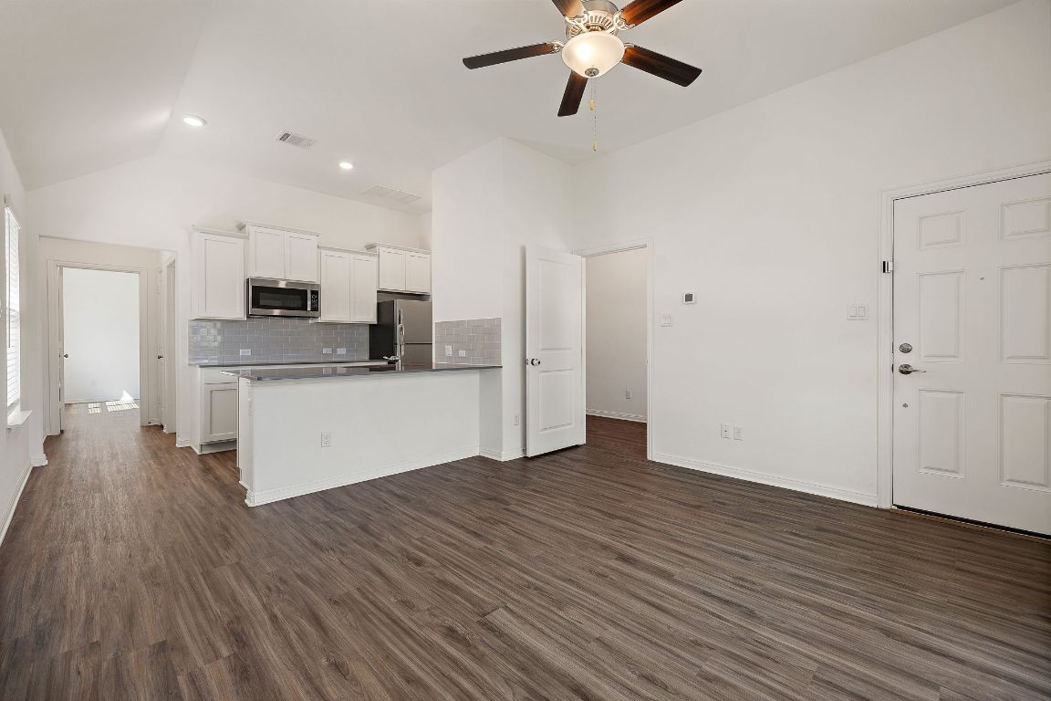 2021 Long Shadow Lane Georgetown, TX 78628 - Photo 17 of 36 a large kitchen with stainless steel appliances granite countertop a wooden floors and white walls