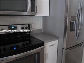 2442 Centergate Drive, Unit 205 Miramar, FL 33025 - Photo 3 of 40 a kitchen with granite countertop white cabinets and stainless steel appliances