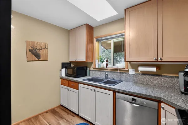 a kitchen with granite countertop a sink and a stove with wooden floor