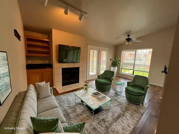 a living room with furniture a flat screen tv and a fireplace