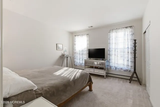 a bedroom with a bed and flat screen tv