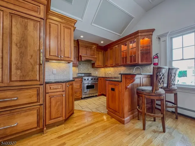 a kitchen with granite countertop wooden cabinets stainless steel appliances a sink and a window