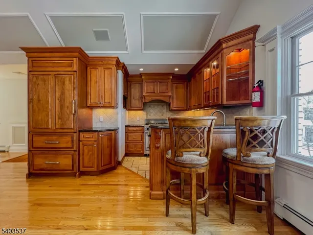 a kitchen with granite countertop a refrigerator and wooden cabinets