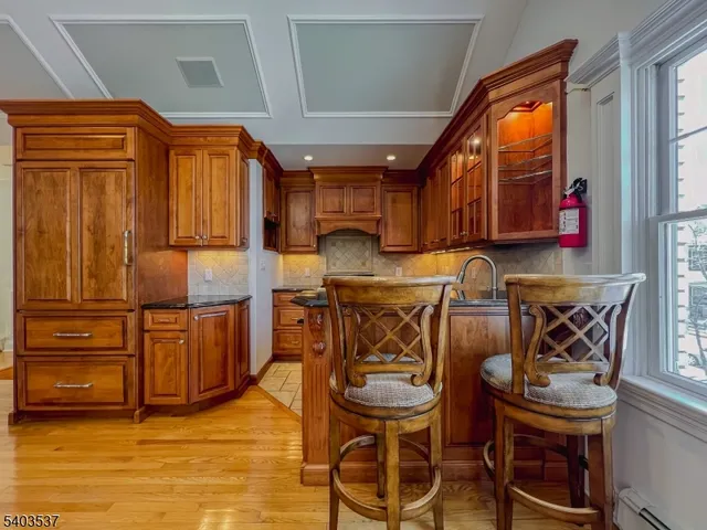 a kitchen with granite countertop a refrigerator and wooden cabinets