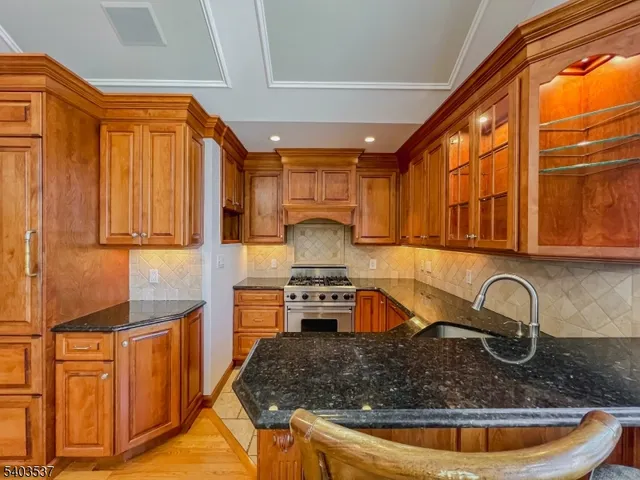 a kitchen with stainless steel appliances granite countertop a sink stove and cabinets