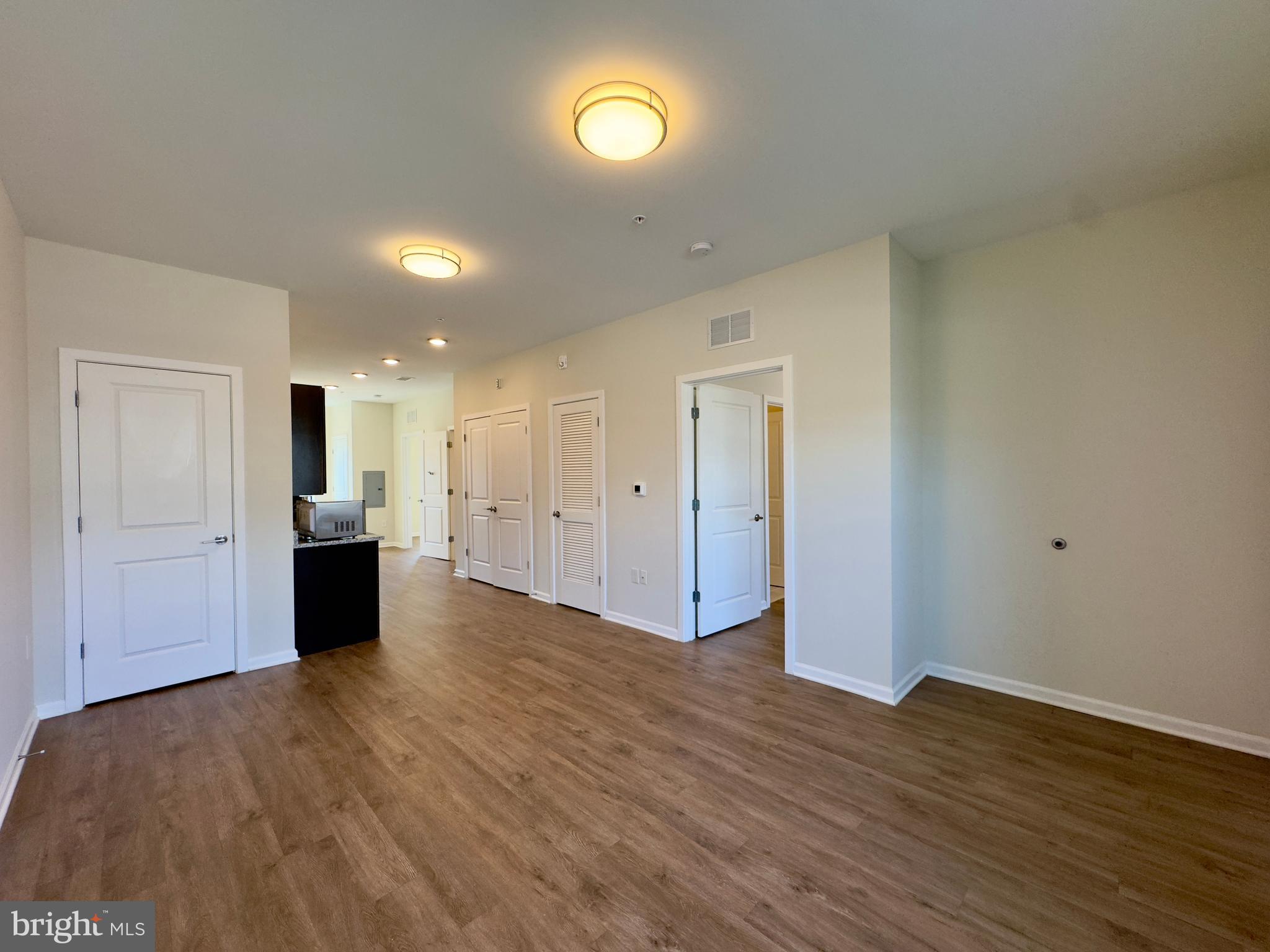 5902 Arizona Avenue, Unit 5902A Baltimore, MD 21206 - Photo 11 of 13 a view of a big room with wooden floor and a kitchen