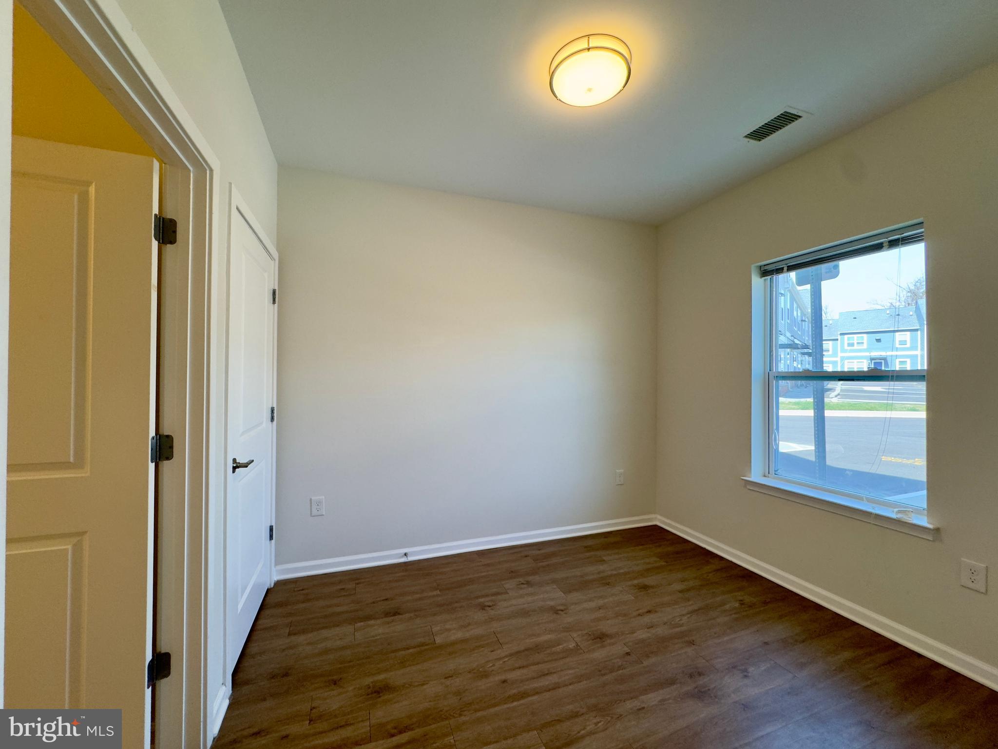 5902 Arizona Avenue, Unit 5902A Baltimore, MD 21206 - Photo 12 of 13 an empty room with wooden floor and windows