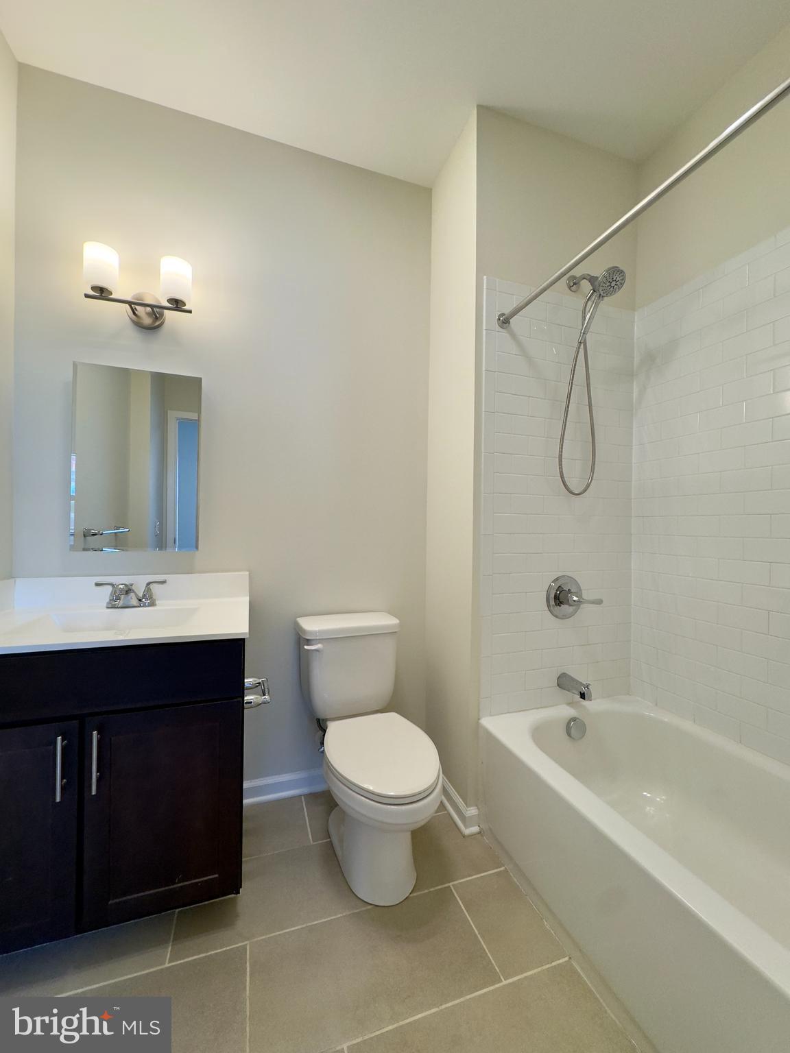 5902 Arizona Avenue, Unit 5902A Baltimore, MD 21206 - Photo 2 of 13 a bathroom with a bathtub shower sink mirror vanity and toilet