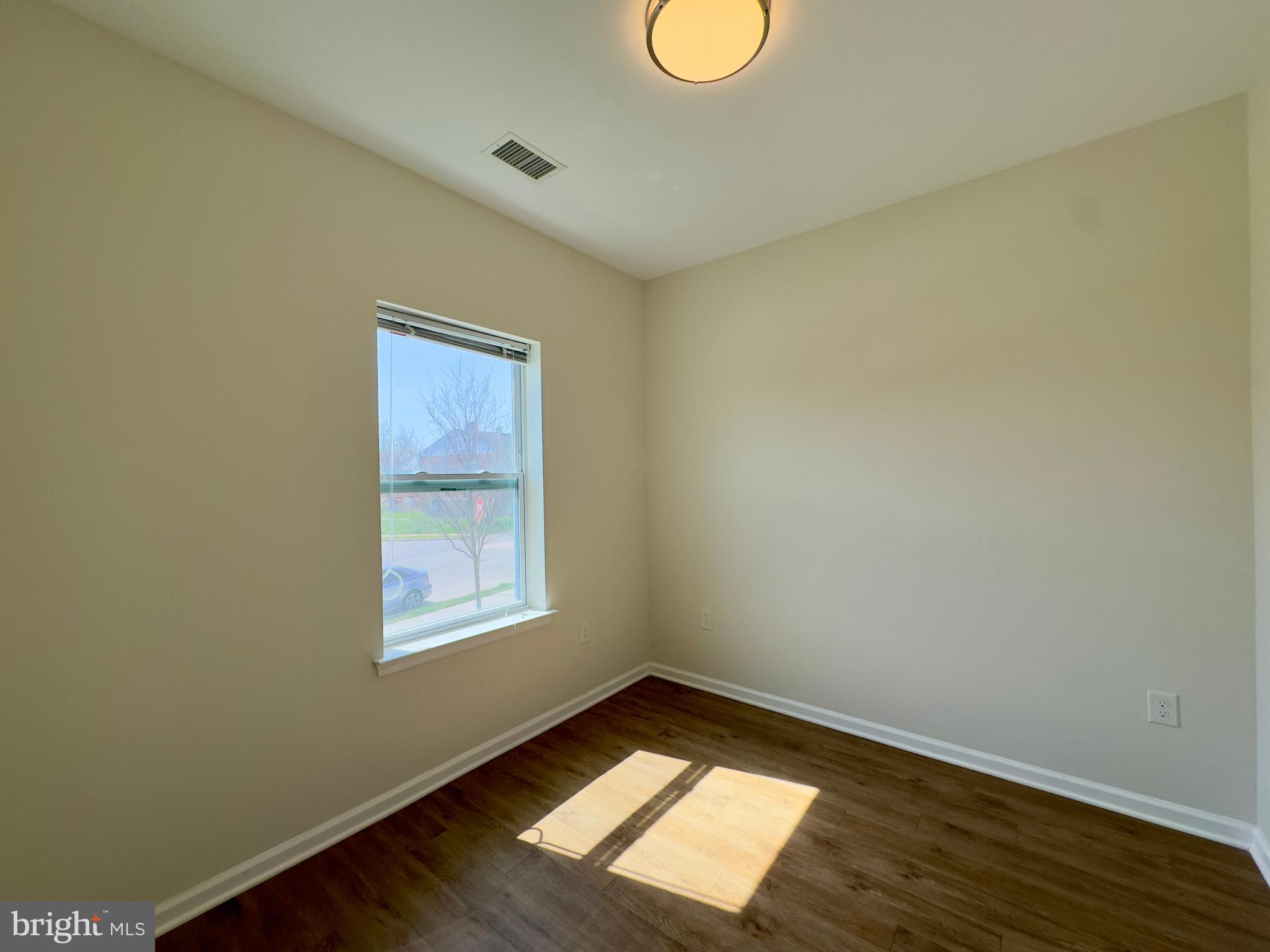 5902 Arizona Avenue, Unit 5902A Baltimore, MD 21206 - Photo 5 of 13 a view of wooden floor and windows in a room