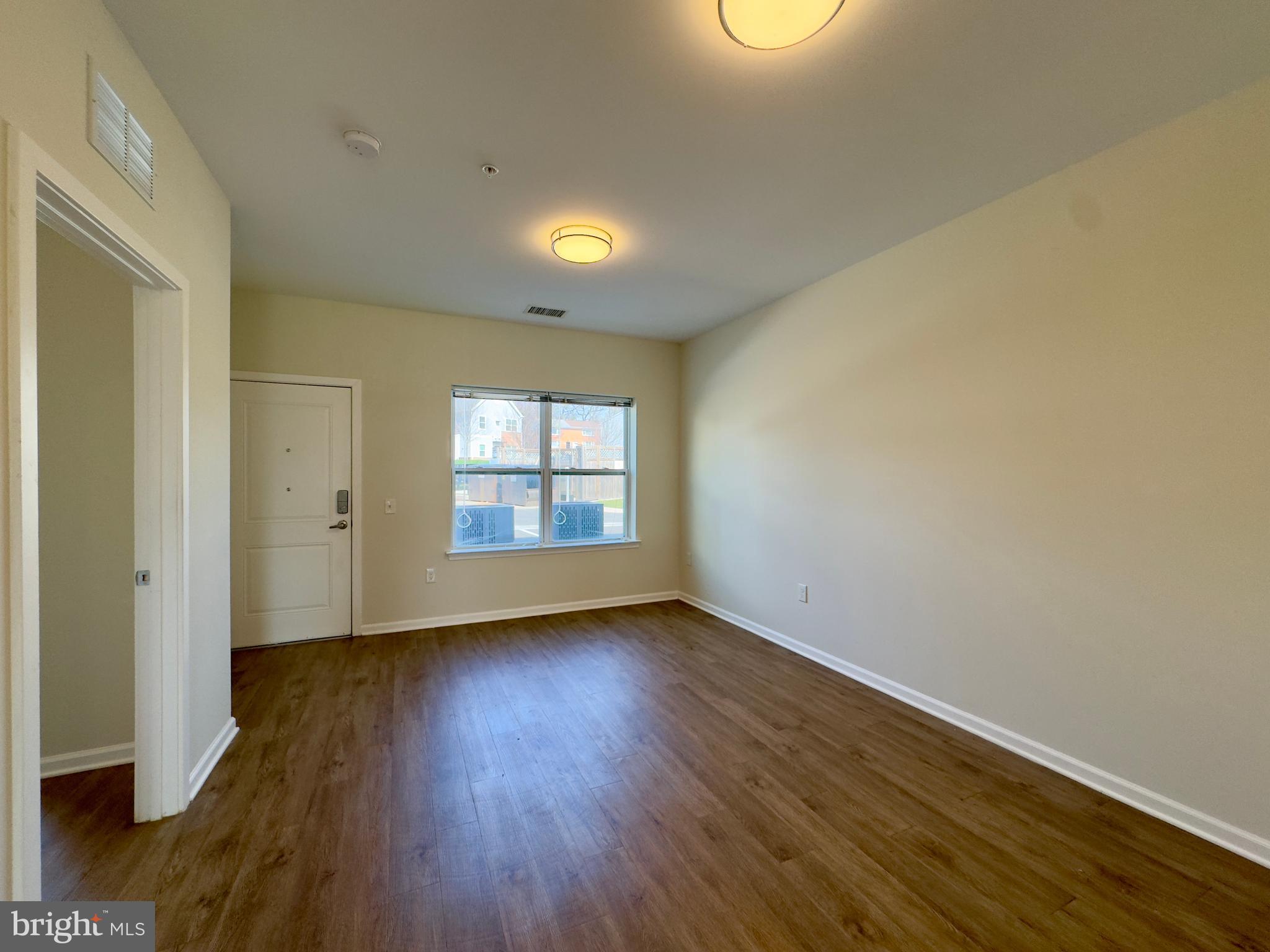 5902 Arizona Avenue, Unit 5902A Baltimore, MD 21206 - Photo 10 of 13 an empty room with wooden floor and windows