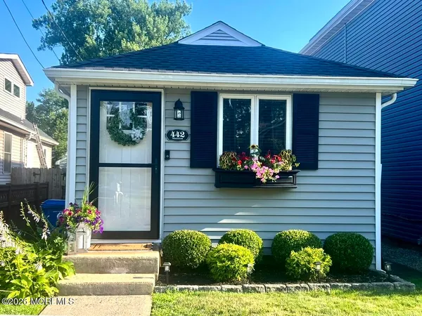 a front view of a house with lots of potted plants