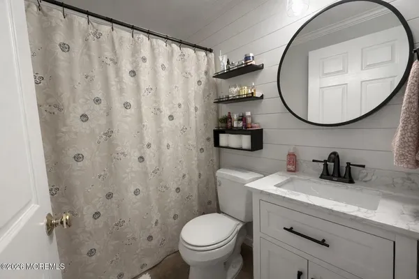 a bathroom with a toilet a sink and a mirror