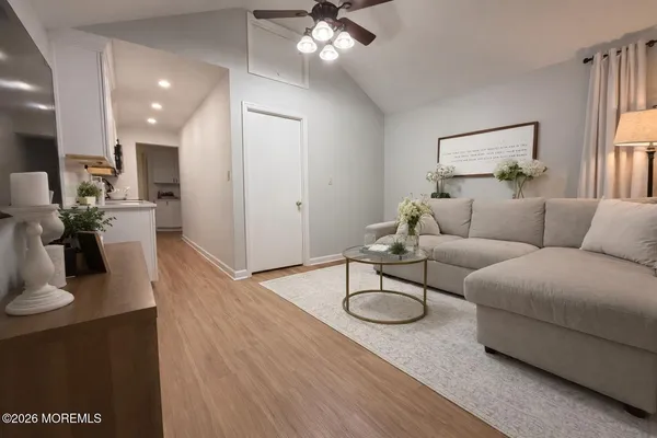 a living room with furniture a large window and wooden floor