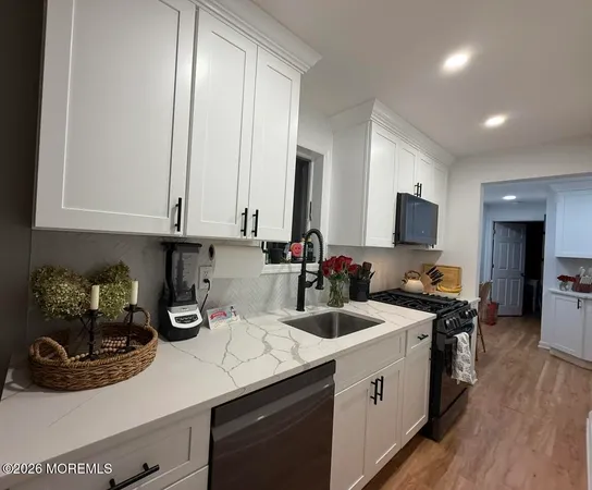 a kitchen with sink a microwave and cabinets