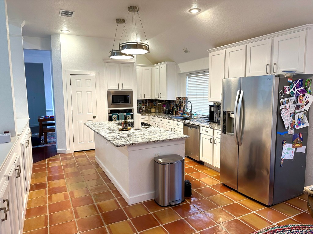 1904 Chasewood Drive Austin, TX 78727 - Photo 3 of 9 a kitchen with granite countertop stainless steel appliances a stove refrigerator and microwave