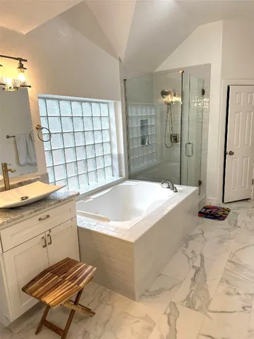 a bathroom with a tub sink and mirror
