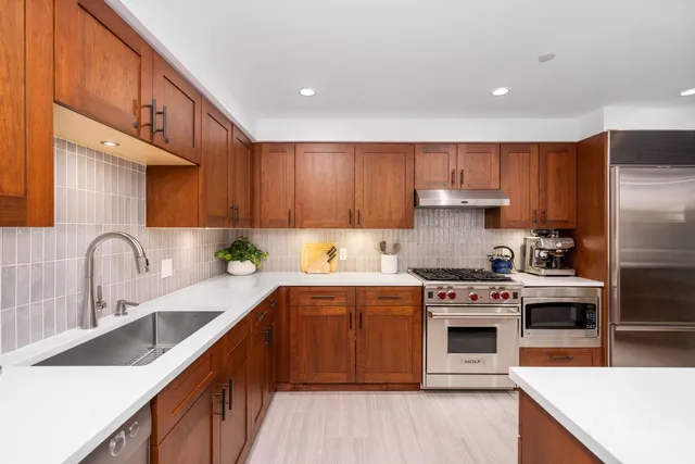 a kitchen with stainless steel appliances granite countertop a sink stove and refrigerator