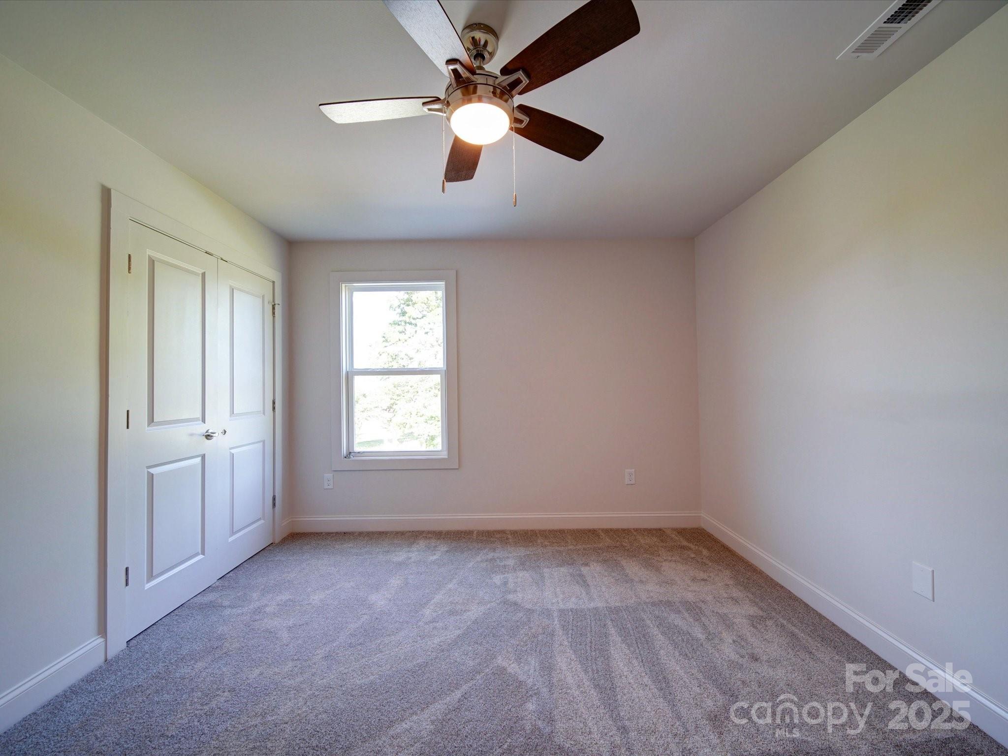 220 Lawyers Road Monroe, NC 28110 - Photo 30 of 36 an empty room with chandelier fan and windows
