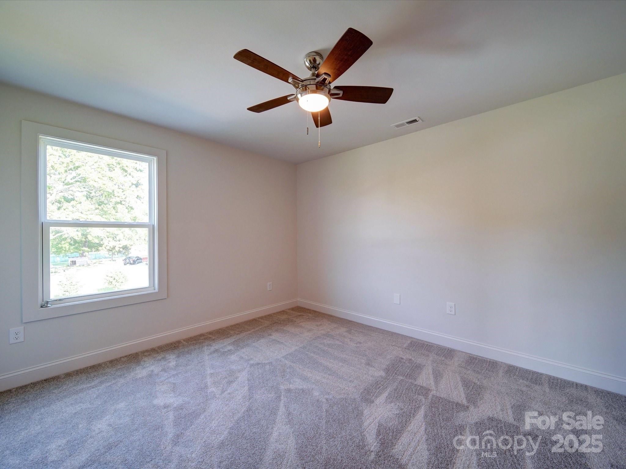 220 Lawyers Road Monroe, NC 28110 - Photo 31 of 36 an empty room with ceiling fan and windows