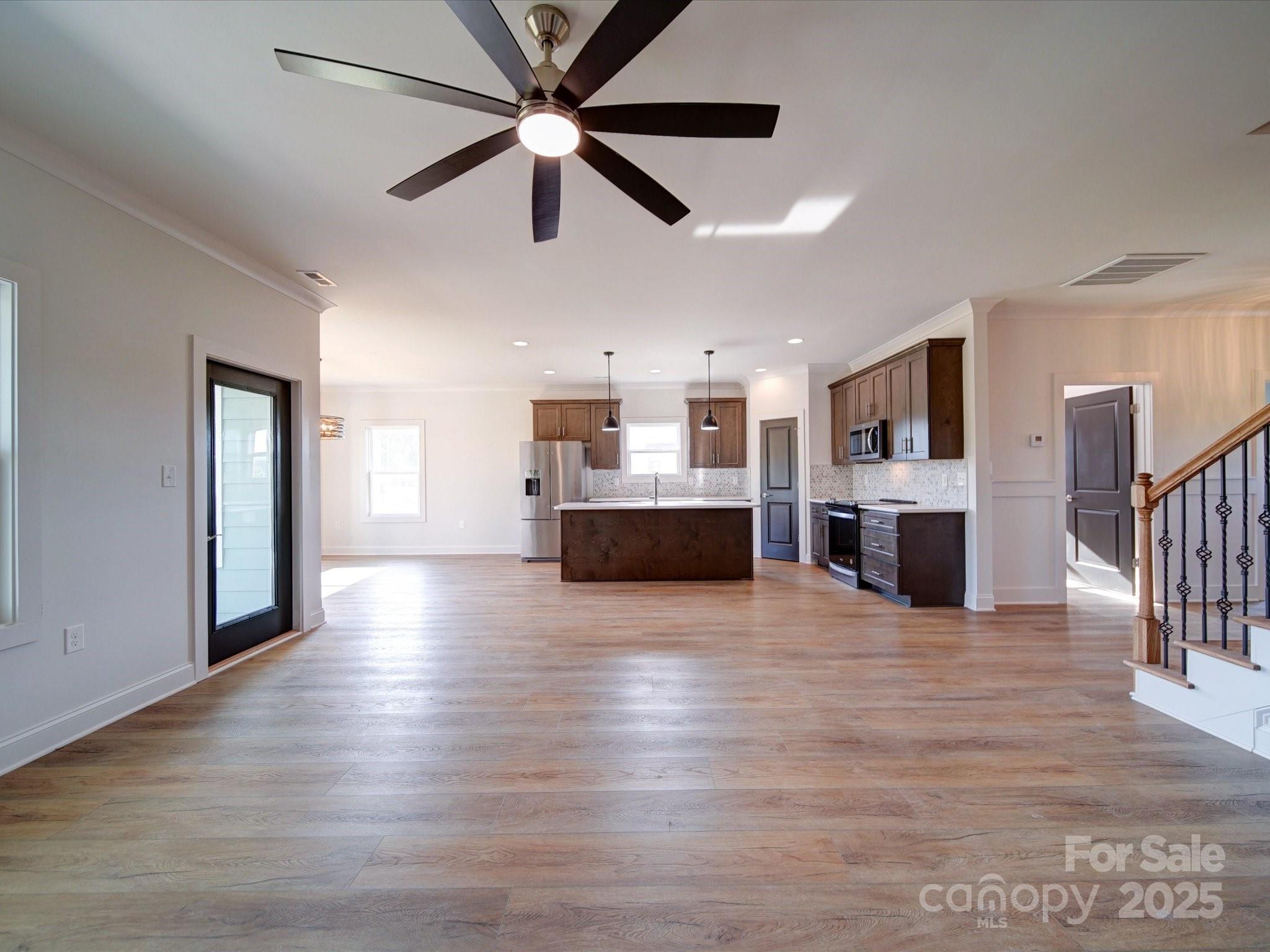 220 Lawyers Road Monroe, NC 28110 - Photo 10 of 36 a view of a big room with wooden floor and a kitchen