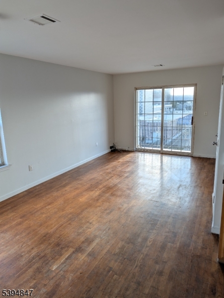 73 Fulton Street Elizabeth Port, NJ 07206 - Photo 5 of 23 wooden floor in an empty room with a window