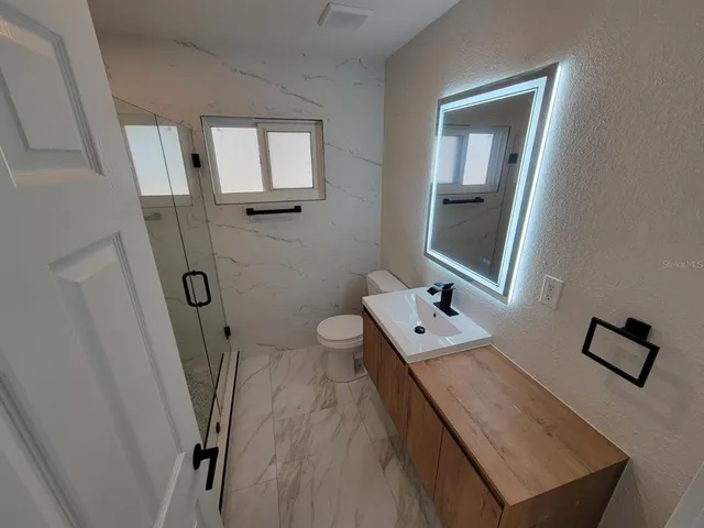 a bathroom with a sink a toilet and mirror