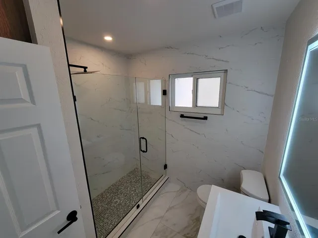 a bathroom with a shower and toilet
