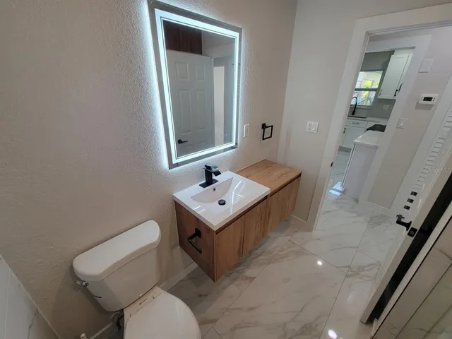 a bathroom with a toilet a sink and a mirror