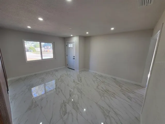 an empty room with windows and cabinet