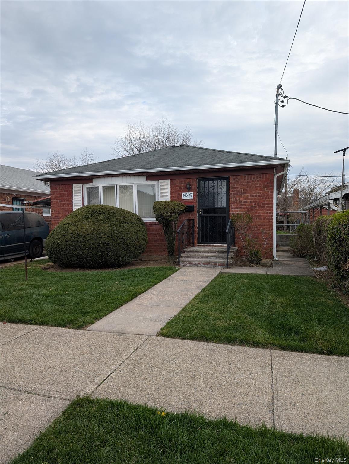 a front view of a house with a garden and plants