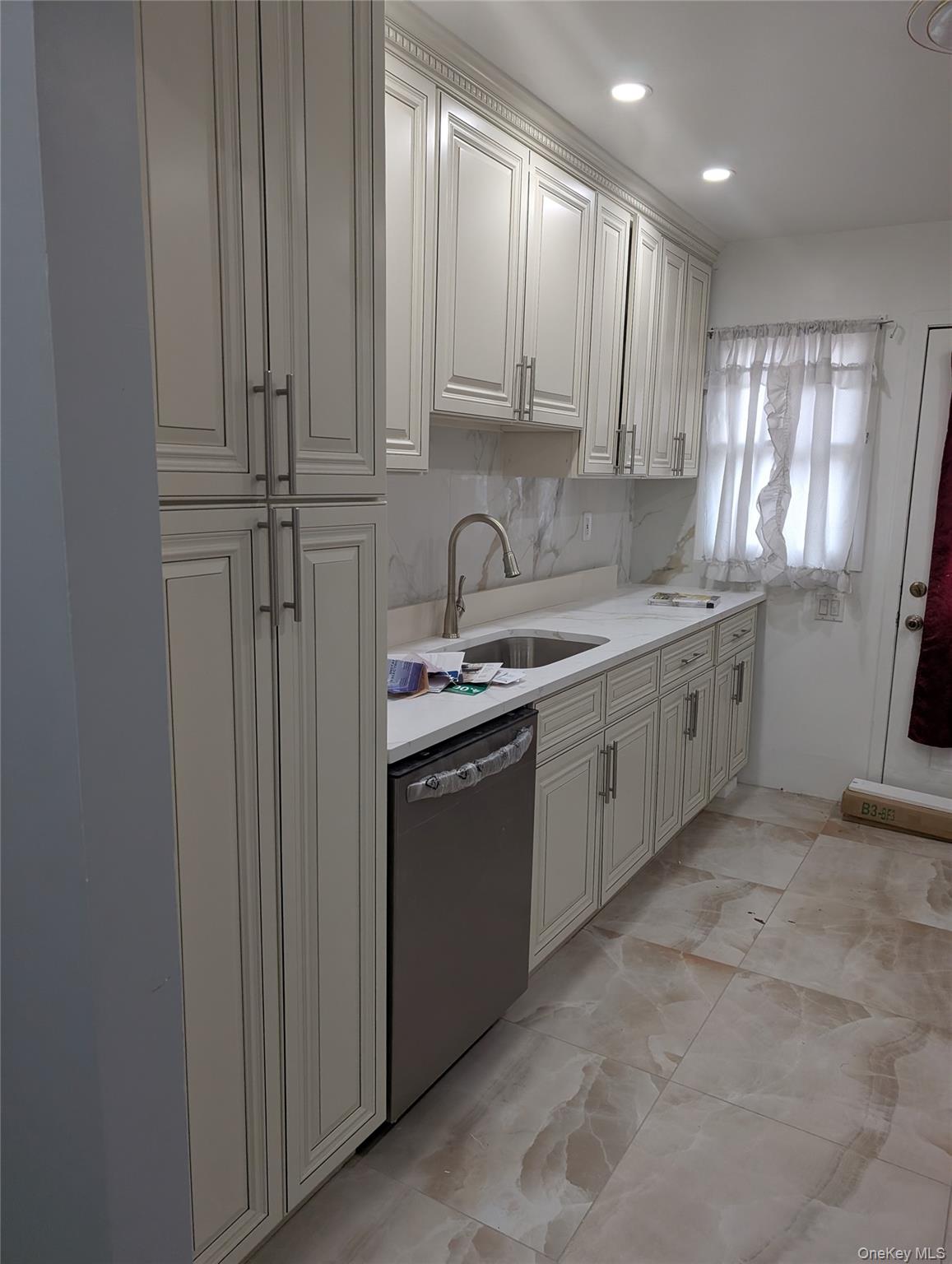 143-47 228th Street Queens, NY 11413 - Photo 17 of 18 a kitchen with stainless steel appliances granite countertop a sink a stove a refrigerator and cabinets