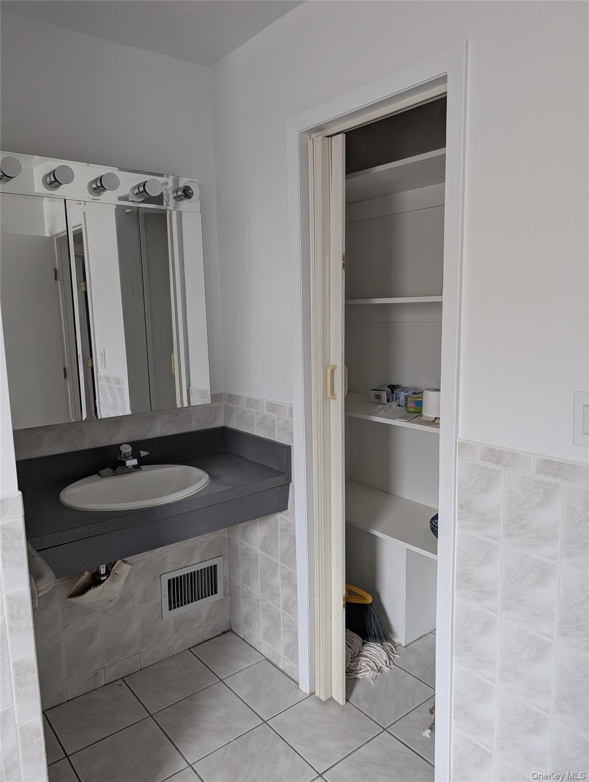 143-47 228th Street Queens, NY 11413 - Photo 6 of 18 a bathroom with a granite countertop sink and a mirror