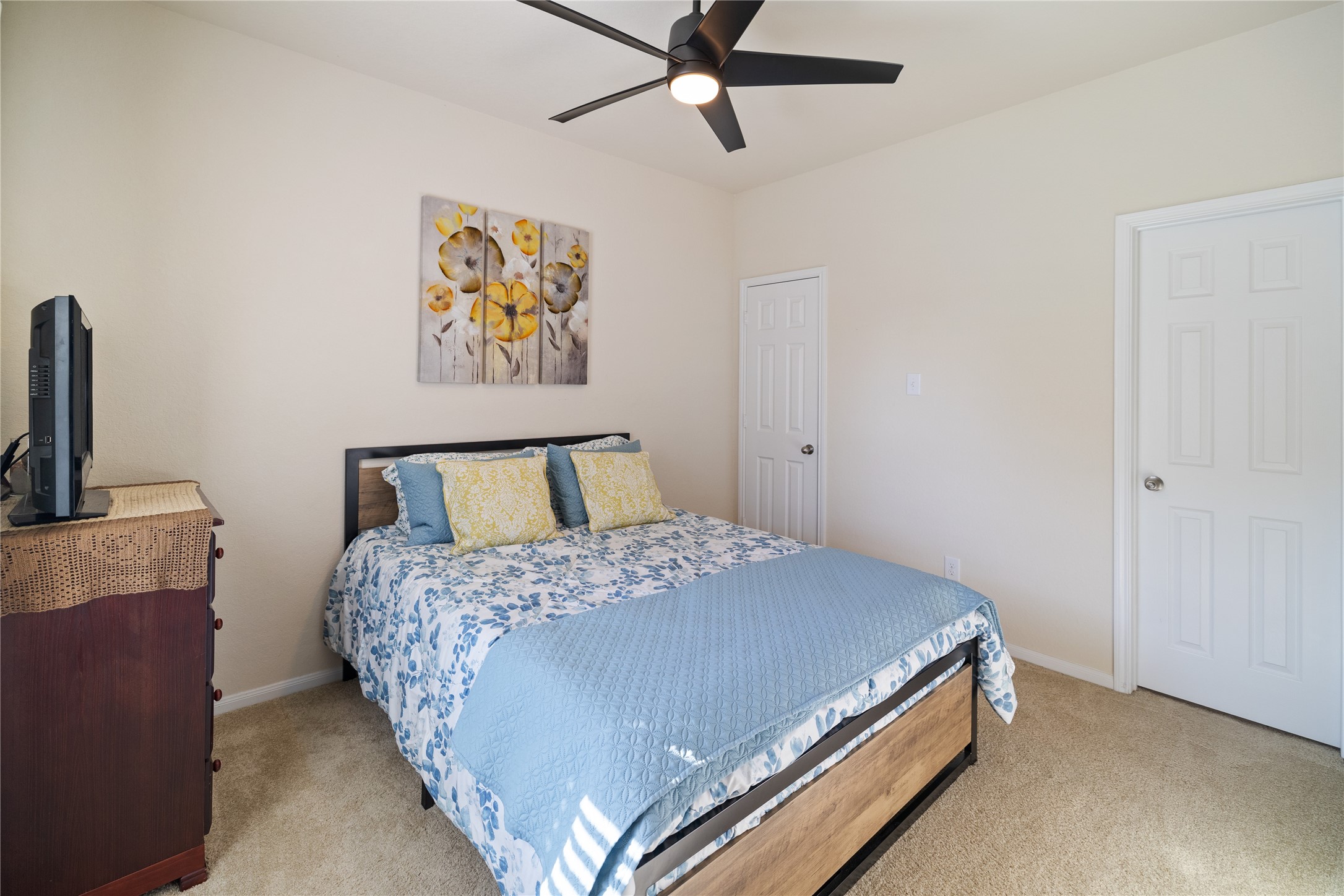 14906 Rustler Gate Lane Cypress, TX 77433 - Photo 11 of 30 a bedroom with a bed and a chandelier