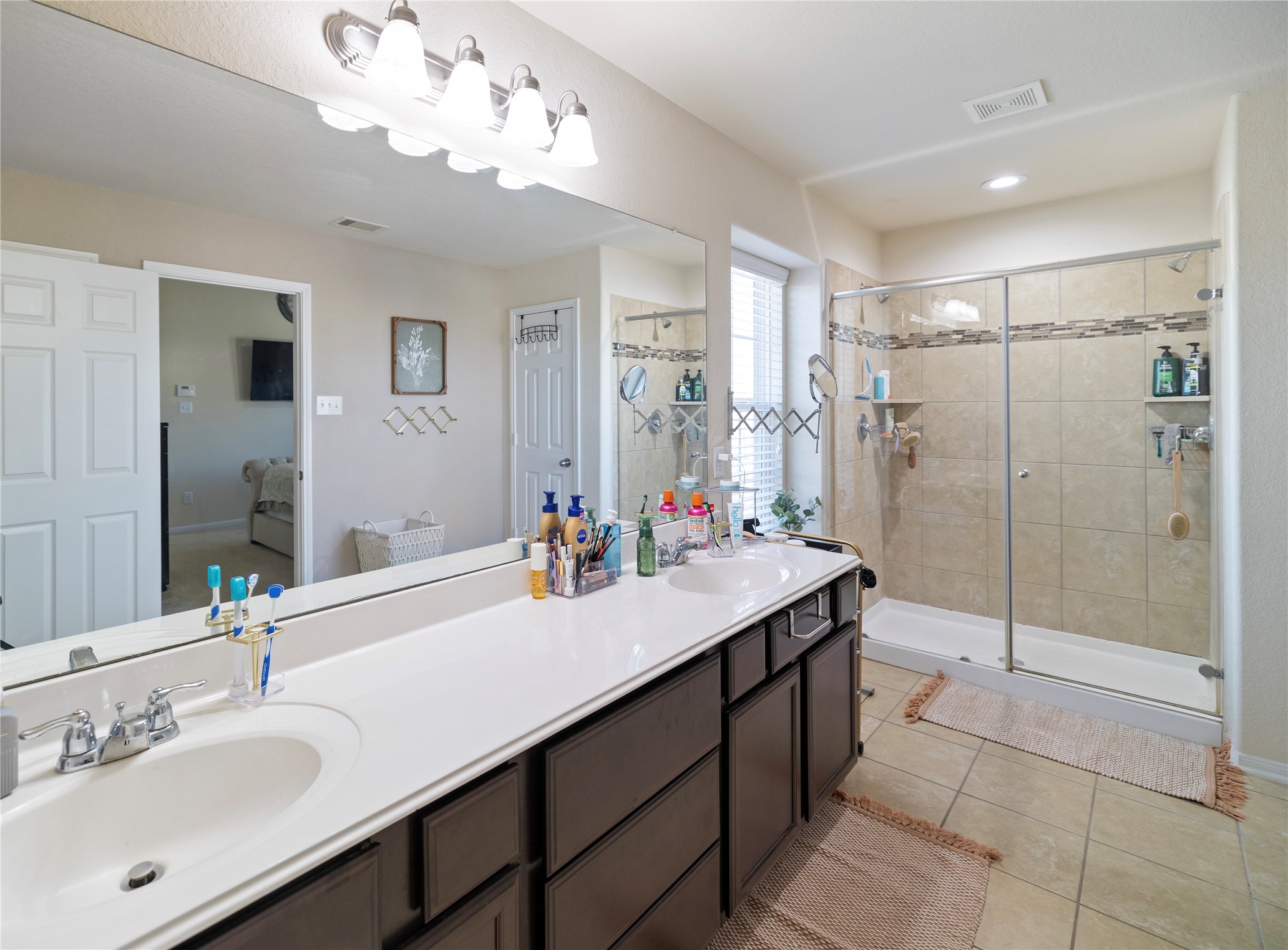 14906 Rustler Gate Lane Cypress, TX 77433 - Photo 20 of 30 a bathroom with a sink double vanity granite tub shower and a mirror