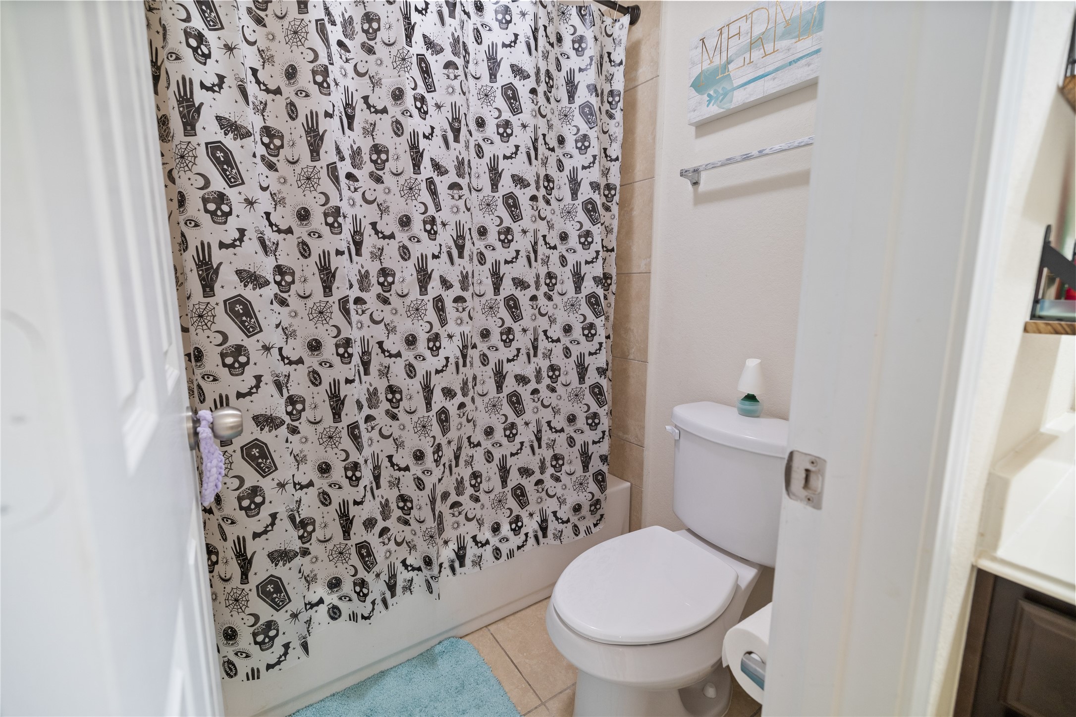 14906 Rustler Gate Lane Cypress, TX 77433 - Photo 25 of 30 a white toilet sitting next to a shower curtain