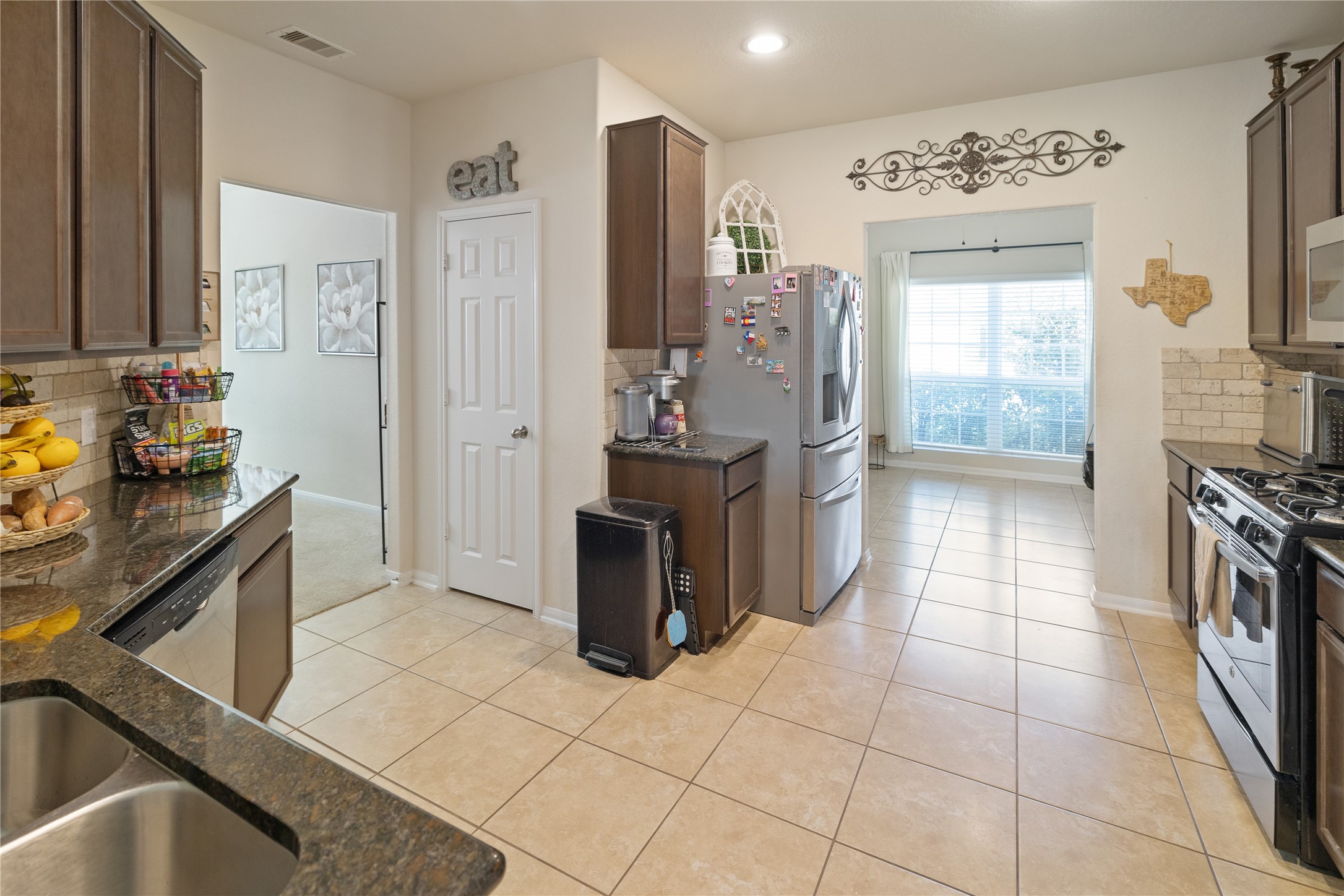 14906 Rustler Gate Lane Cypress, TX 77433 - Photo 6 of 30 a kitchen with stainless steel appliances a stove a sink and a refrigerator