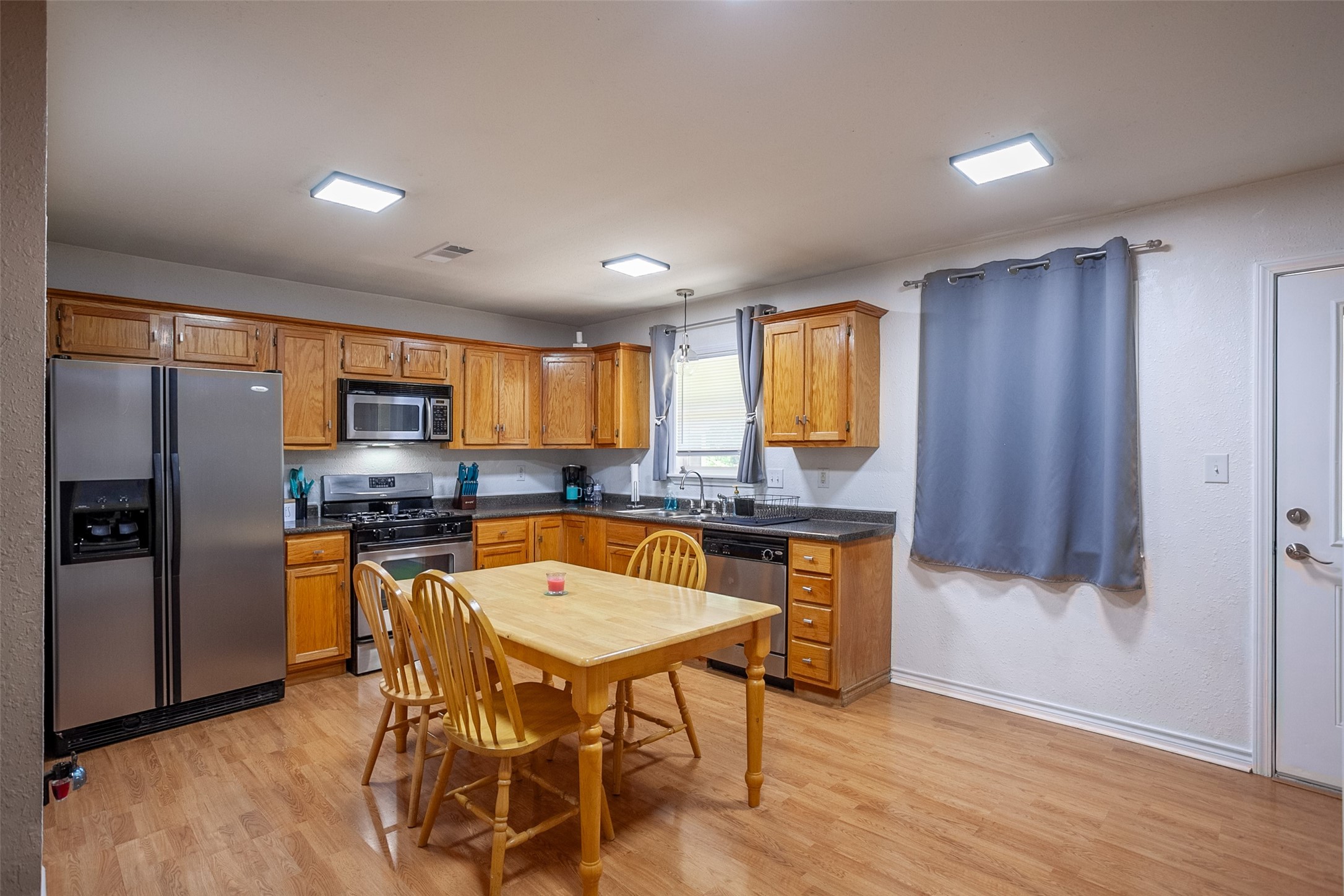 2704 62nd Street Port Arthur, TX 77640 - Photo 10 of 30 a kitchen with stainless steel appliances granite countertop a kitchen island a table and chairs in it