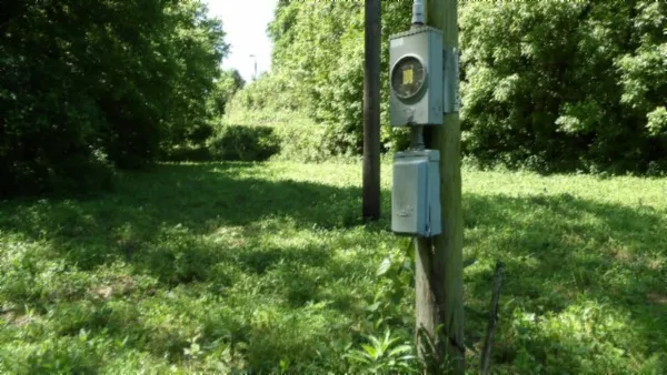 a view of a grassy field with trees in the background