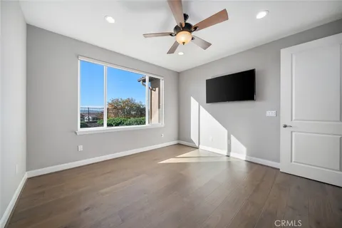 a view of empty room with wooden floor and window