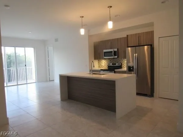 a kitchen with kitchen island a counter top space appliances and a ceiling fan