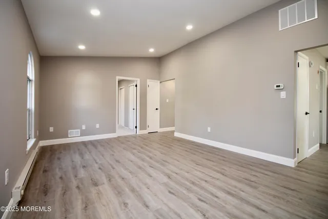 a view of an empty room with wooden floor