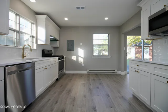 a kitchen with a wooden floor and white cabinets